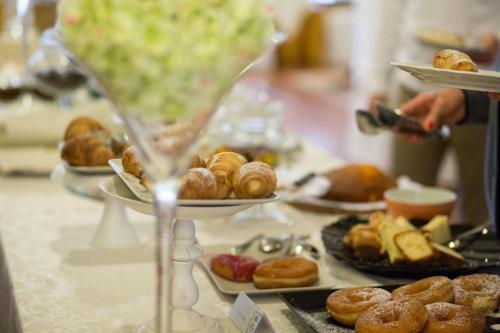 a table with a bunch of pastries and a plate of donuts at Parco del Lago Resort & SPA in Villagrande