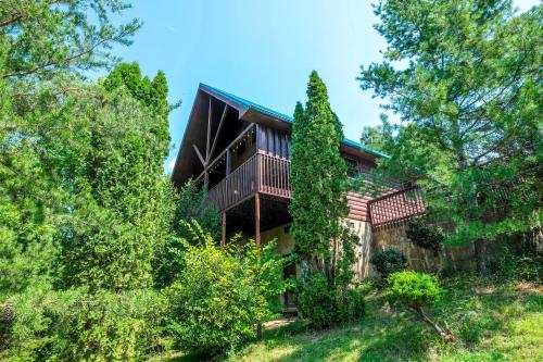 a large house with a balcony and trees at My Pigeon Forge Cabin in Pigeon Forge