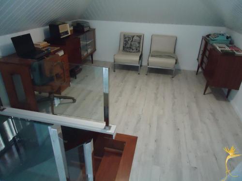 a living room with a desk and a chair and a desk and a desk at A Casa Estrelícia-Dourada Garcês in São Vicente