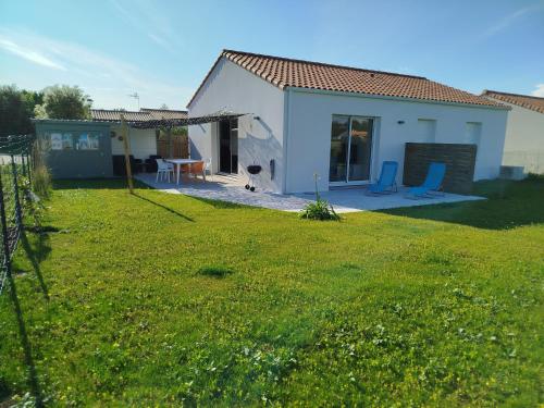 une petite maison blanche avec une cour dans l'établissement Ladybird Maison 4 à 5 pers climatisée, à Longeville-sur-Mer