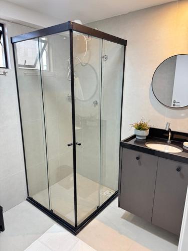 a glass shower in a bathroom with a sink at Áurea Flat Cabo Branco in João Pessoa