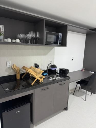 a kitchen with a sink and a counter with a microwave at Áurea Flat Cabo Branco in João Pessoa