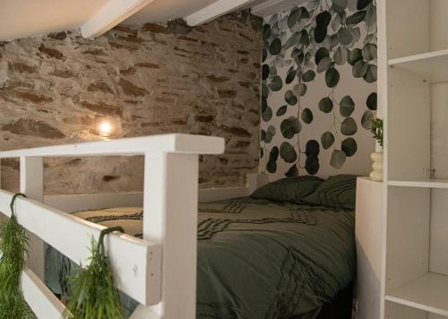 une chambre avec un lit et un mur de briques dans l'établissement Petit appartement lumineux, à Les Sables-dʼOlonne