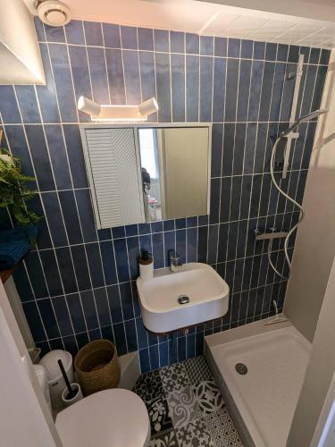 une salle de bain avec un lavabo, des toilettes et un miroir dans l'établissement Petit appartement lumineux, à Les Sables-dʼOlonne