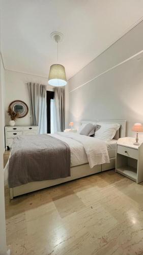 a white bedroom with a large bed and a table at Villaggio View in Kariá