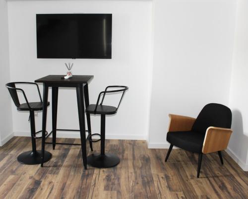 a table and chairs with a television on a wall at Loft Prestige in Leiria
