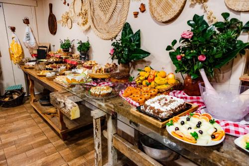 una mesa llena de muchos tipos de alimentos diferentes en Pousada Rosa Maria, en Erechim