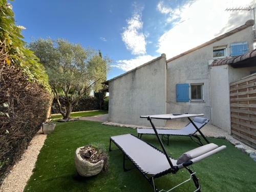 d'une terrasse avec un banc et une table dans la cour. dans l'établissement Maison provençale, à Eyguières