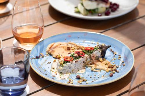 a plate of food on a table with glasses of wine at The Westin Resort, Costa Navarino in Romanós