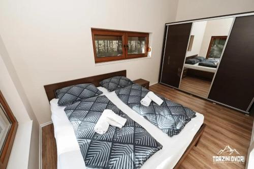 a large bed in a room with a mirror at Vikendica Tarzini dvori - privatnost na 2000m2 in Tomislavgrad