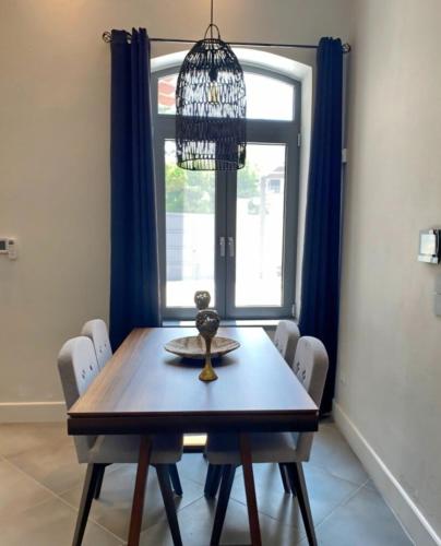 a dining room table with chairs and a chandelier at Venetian gem in neapolitan with private courtyard in Neápolis