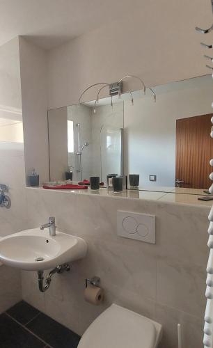 a bathroom with a toilet and a sink and a mirror at Ferienwohnung sunset Weissenstadt in Weißenstadt