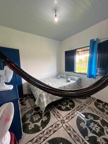 a bedroom with a hammock in the middle of a room at Canto da Sereia - Casa in Soure