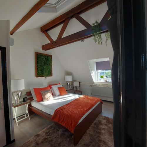 a bedroom with a large bed with orange pillows at The Rooftop Retreat - by The M House in Arnhem