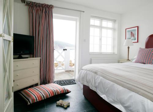 a bedroom with a bed and a television and a window at Cary Arms & Spa in Torquay