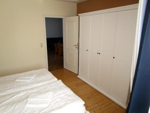 an empty bedroom with a bed and a closet at Hotel garni SEESCHLÖSSCHEN in Kolpinsee