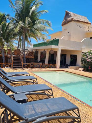 a resort with a swimming pool with lounge chairs at La Bocania in Progreso