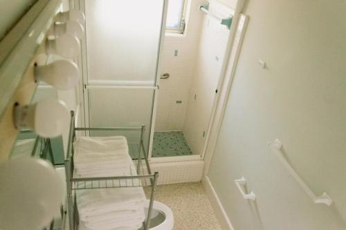 a bathroom with a shower and a toilet with a mirror at Elegant Escape by Indian Rocks in Largo