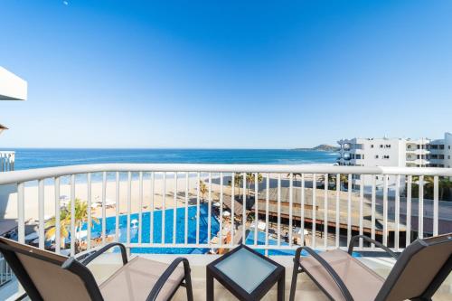 a balcony with chairs and a view of the beach at Krystal Grand Los Cabos - All Inclusive in San José del Cabo