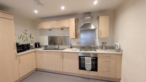 a kitchen with wooden cabinets and a stove top oven at Beautiful and Central Apartment in Newcastle City in Central Station