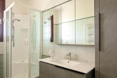 a white bathroom with a sink and a shower at Agriturismo Agricola Cassiano in Morciano di Leuca