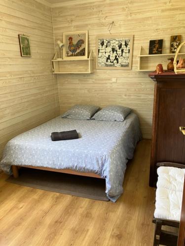 a bedroom with a bed in a room with wooden floors at Chambres d hôte du Puy des Gardes in Meymac