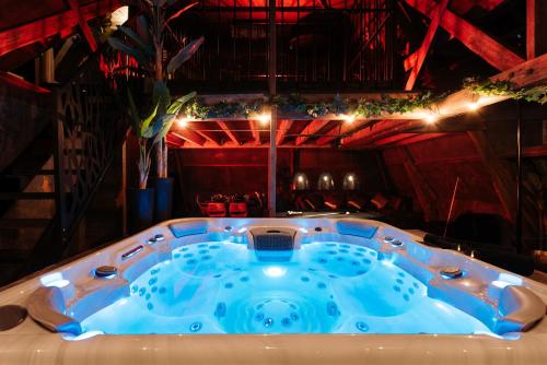 a jacuzzi tub in the middle of a room at Intense Experience - Suites wellness avec piscine jacuzzi sauna billard privatifs in Manage