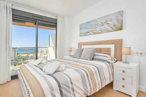 a white bedroom with a large bed and a window at Un Sueño Realidad En Torrox in Los Llanos