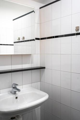 a white bathroom with a sink and a mirror at Rancho Bejarano in Kollumerpomp