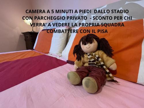 wypchana lalka siedzi na łóżku w obiekcie Affittacamere Room Rental Pisa w Pizie