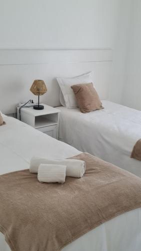 dos camas sentadas una al lado de la otra con toallas. en Apartamento Alagoinha by Umbral, en Vila Nova de Milfontes