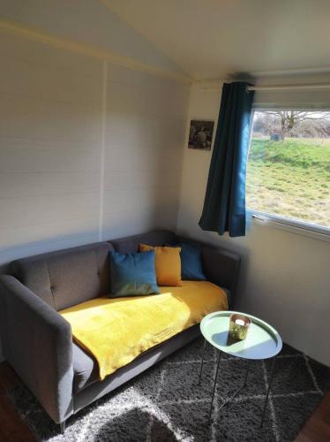 un salon avec un canapé et une table dans l'établissement le hangar 87, à Bussière-Portevine