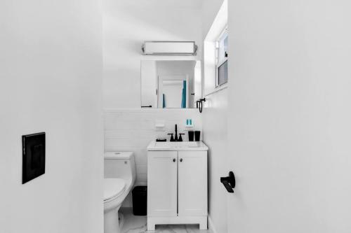 ein weißes Badezimmer mit Toilette und Waschbecken in der Unterkunft Relax & Fun Hollywood Private Pool | Arcade Game in Hollywood