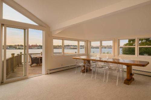 a dining room with a table and some windows at Stay at Rocky Neck in Gloucester