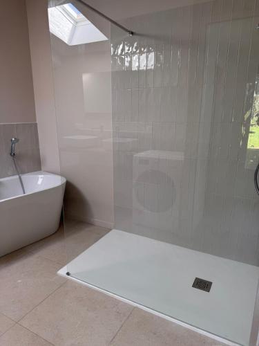 une salle de bain avec douche et baignoire et toilettes dans l'établissement Maison familiale neuve, plage à 3min, jardin, à Assérac