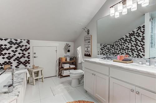 a white bathroom with a toilet and a sink at Immaculate Waterfront Family Home for 16 w Private Dock in Kingsland