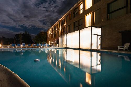 a swimming pool in front of a building at night at San Miguel Plaza Hotel All Inclusive in Villa San Miguel