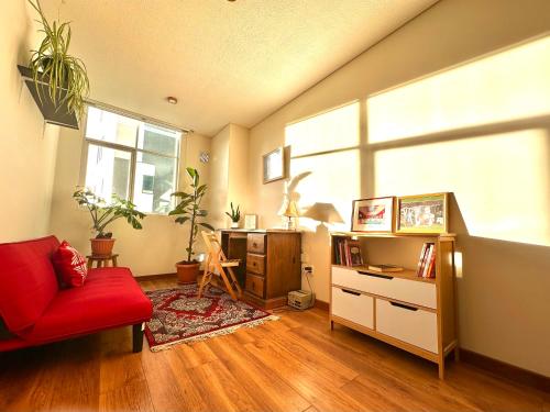 a living room with a red couch and a red chair at Lujoso y soleado departamento en Sopocachi in La Paz