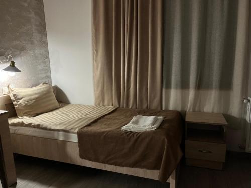 a small bed in a bedroom with a curtain at Ninama in Mestia