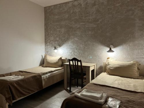 a room with two beds and a desk and a chair at Ninama in Mestia