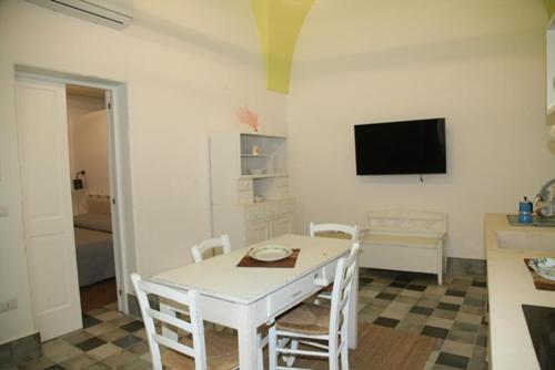 a dining room with a white table and chairs at Residenza Storella 18 in Alessano