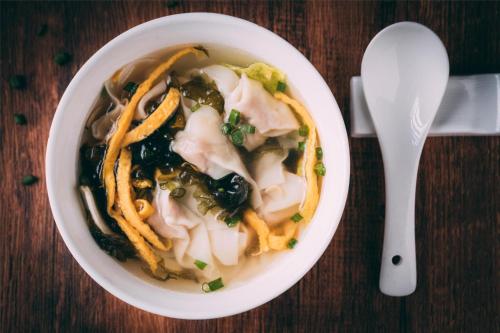 a bowl of soup with noodles and a spoon at Kempinski The One Suites Hotel Shanghai Downtown in Shanghai