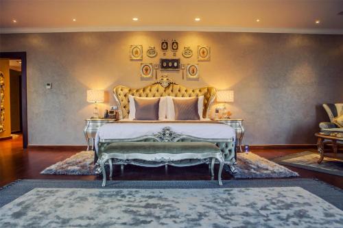 a bedroom with a large bed with a gold headboard at Royal Maxim Palace Kempinski Cairo in Cairo