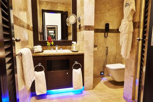 a bathroom with a sink and a toilet and a mirror at Royal Maxim Palace Kempinski Cairo in Cairo