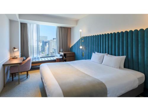 a hotel room with a large bed and a window at THE KNOT HIROSHIMA - Vacation STAY 20580v in Hiroshima