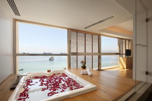a bathroom with a bath tub filled with red petals at Kempinski Hotel Aqaba in Aqaba