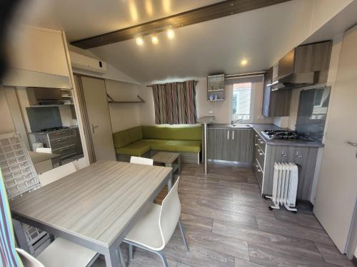 une cuisine et une salle à manger avec une table et des chaises dans l'établissement mobil home, à Lit-et-Mixe