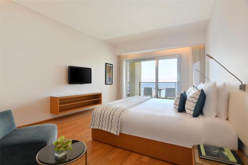 a hotel room with a large bed and a tv at Kempinski Hotel Aqaba in Aqaba