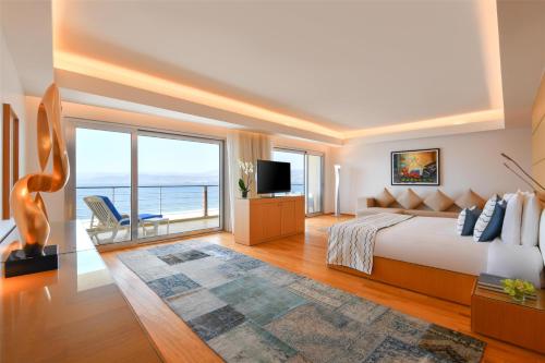 a bedroom with a large bed and a large window at Kempinski Hotel Aqaba in Aqaba