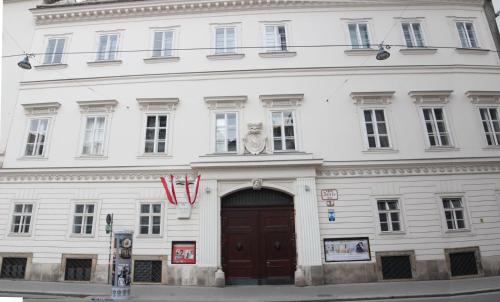 a large white building with a brown door at DATRI Petite Suite 6 in Vienna